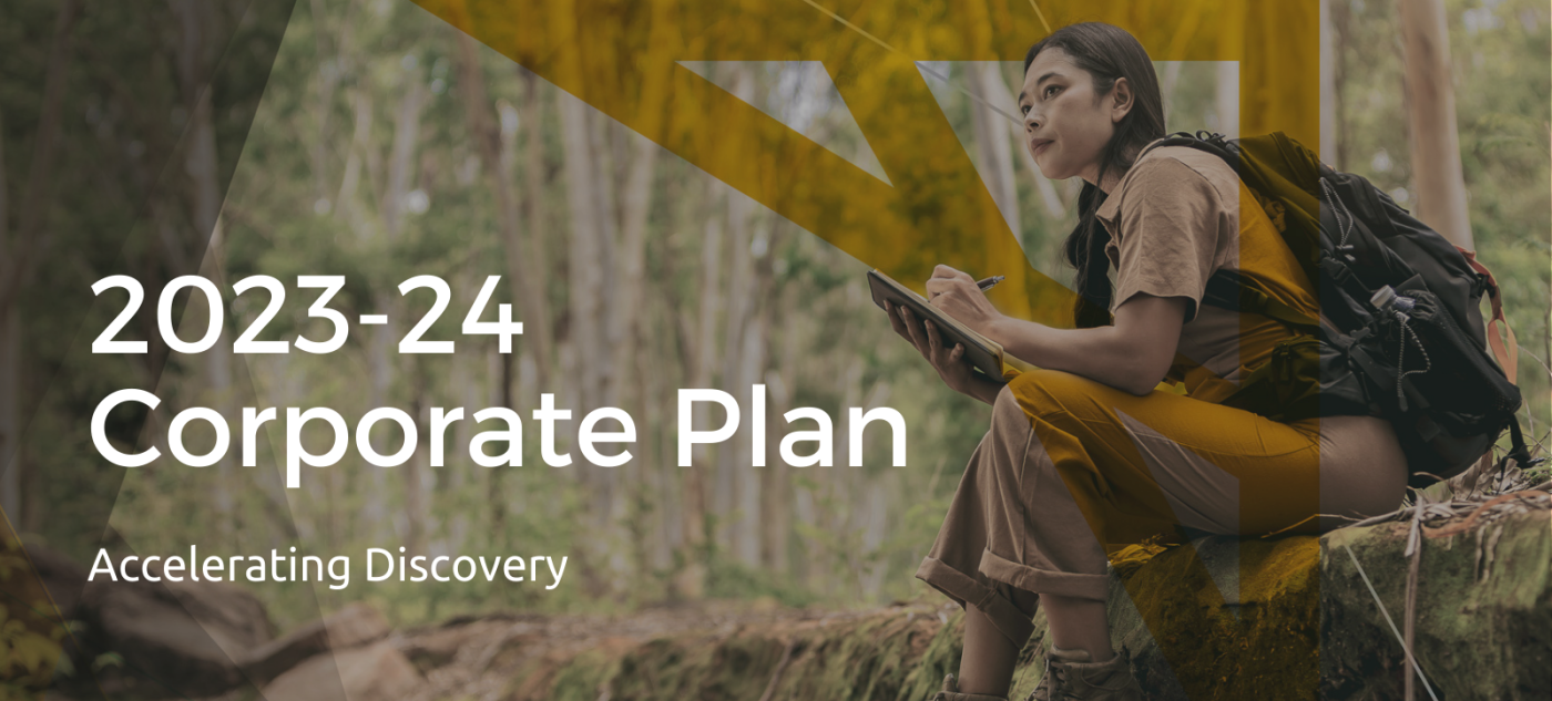 A picture of a person sitting in a forest, taking notes, with the text "2023-24 Corporate Plan. Accelerating Discovery" on top.