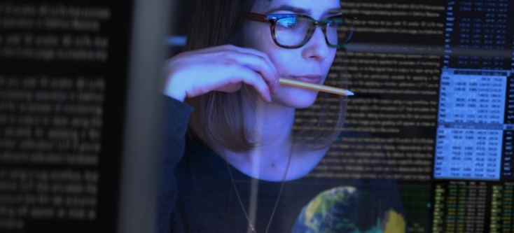 Reflection of a woman looking at a computer screen